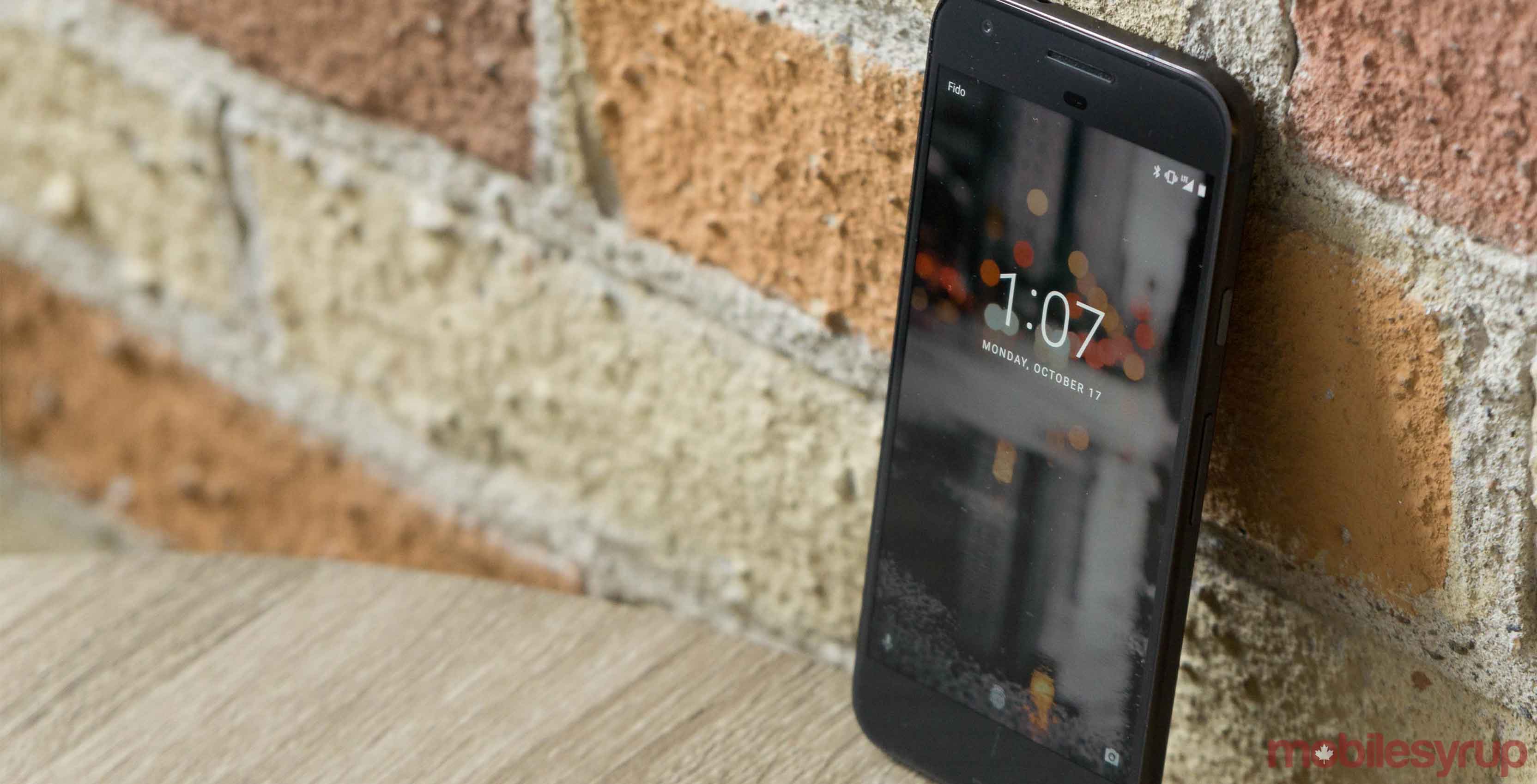 Google's Pixel smartphone leaning against a brick wall