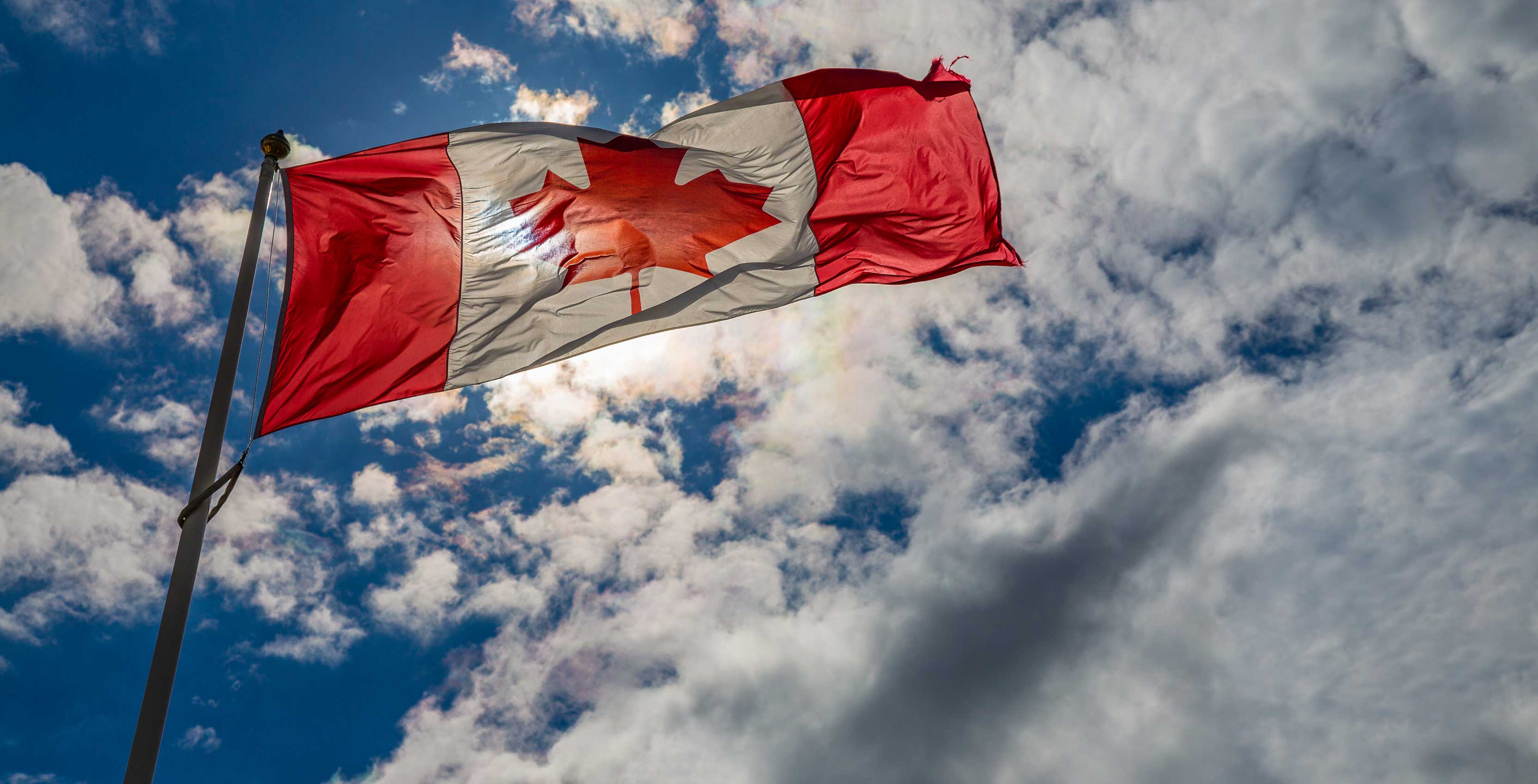 Canadian Flag with blue sky and clouds