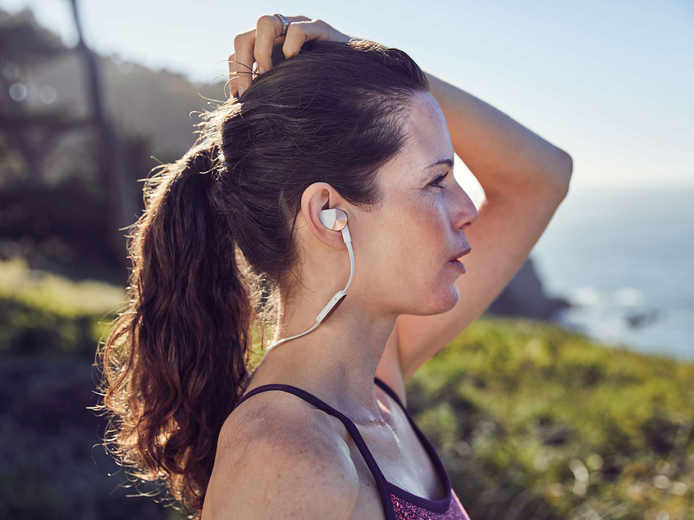 Woman wearing Fitbit Flyer headphones in lunar gray