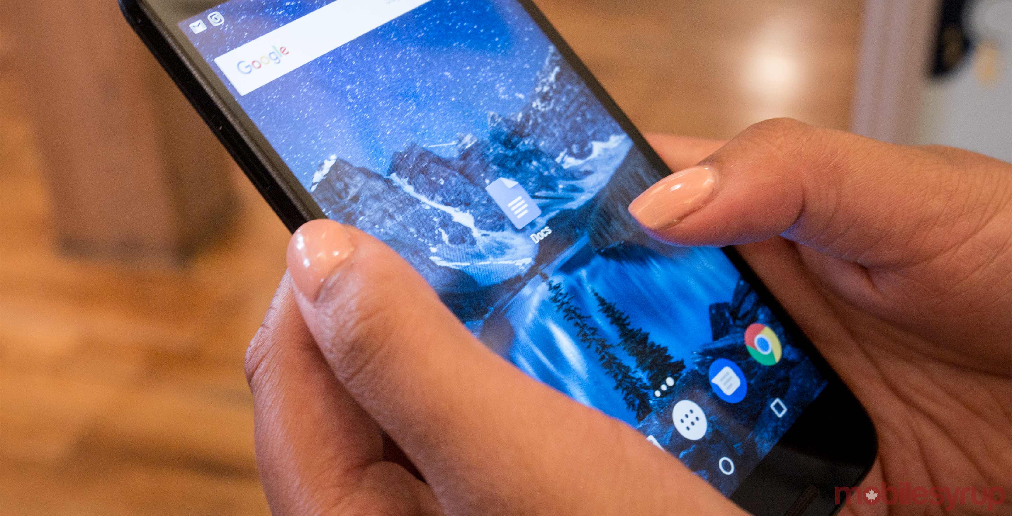 An image showing a hand holding a Nexus 5X with the Google Docs app on-screen