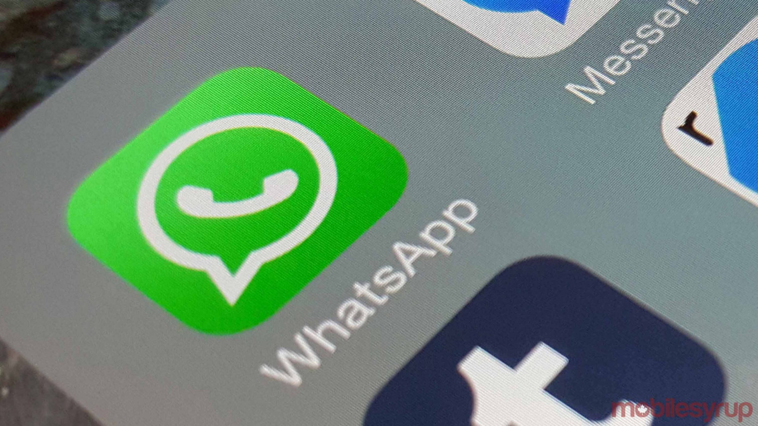 WhatsApp icon on a phone home screen.