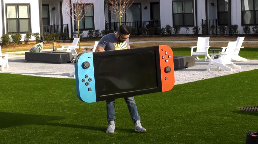 Michael Pick holding the worlds largest Nintendo Switch
