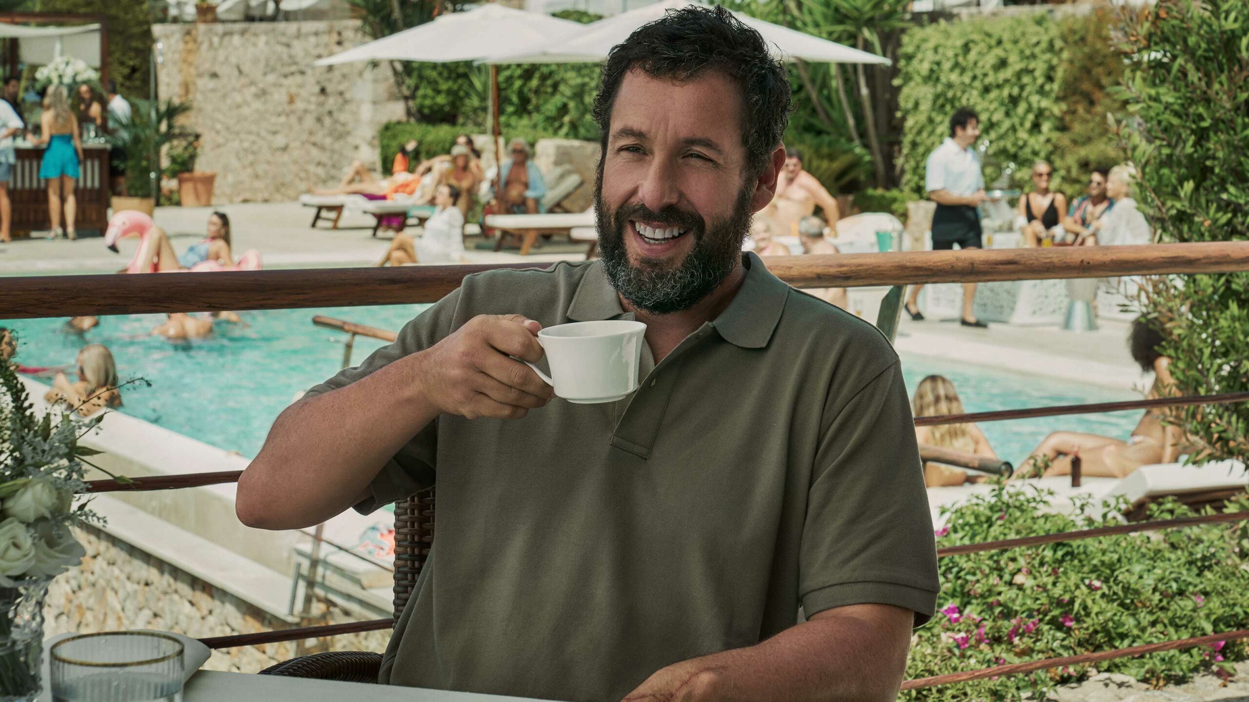 Adam Sandler drinking a coffee and laughing in Netflix's Hustle