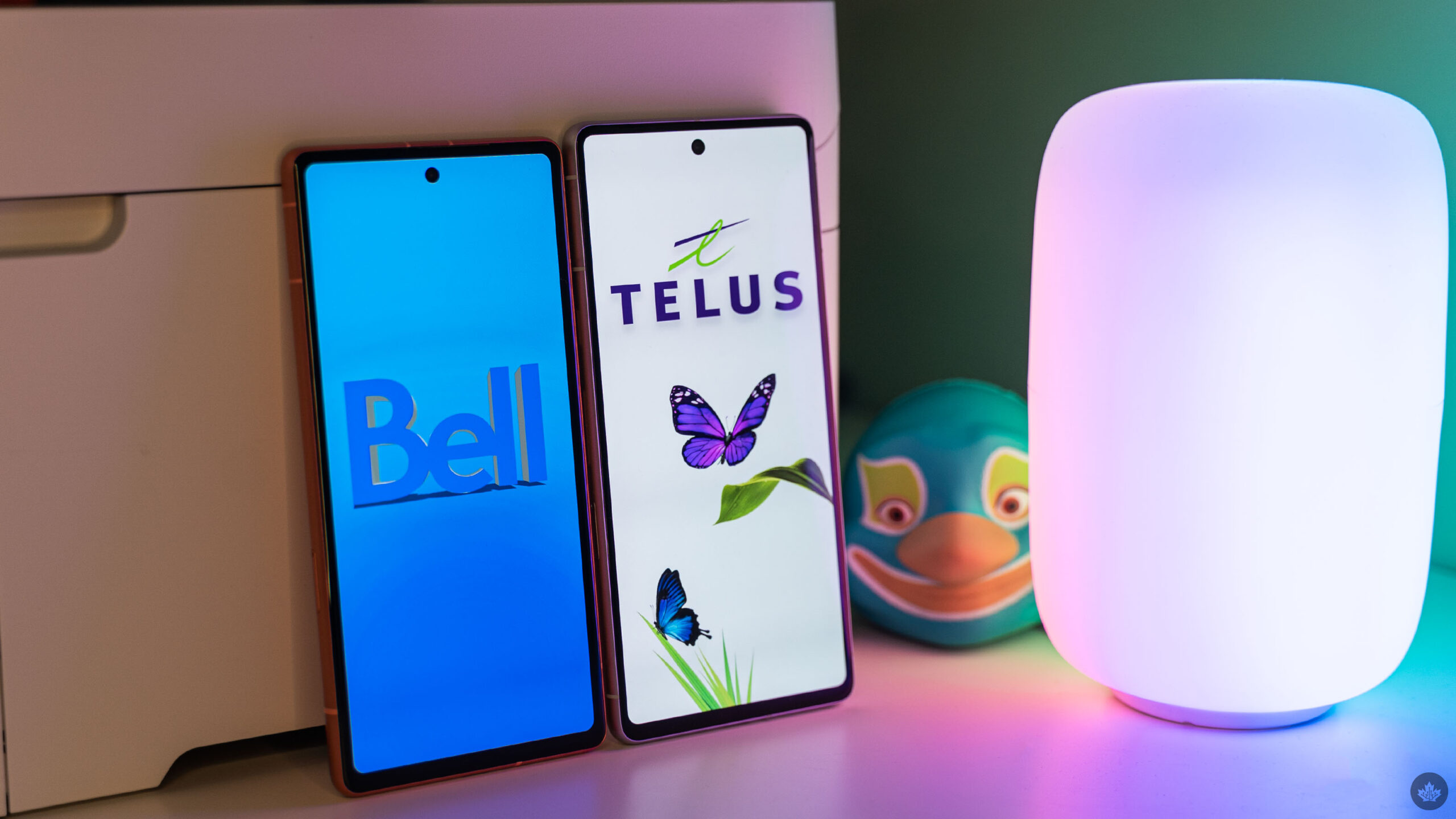 Bell and Telus logos on smartphones.