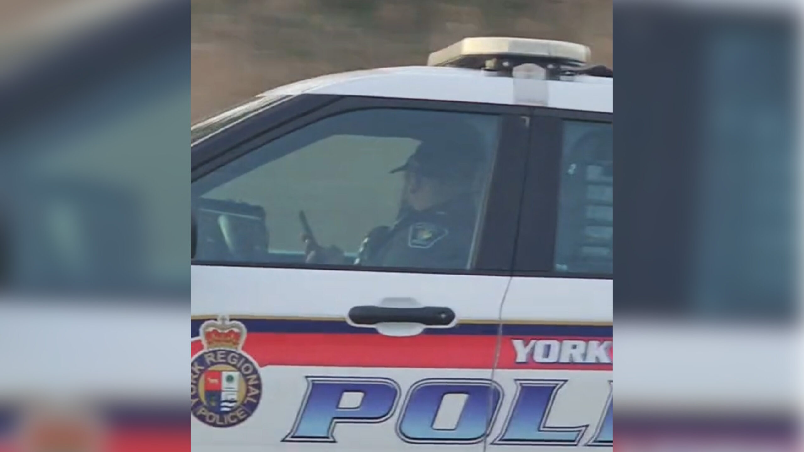 Screenshot from a video showing a York Regional Police officer using their phone while driving.